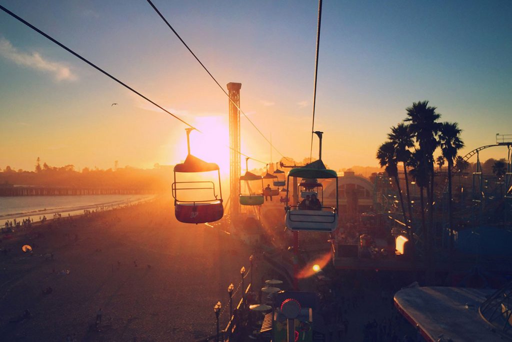 Visitors enjoy a amusement ride during sunset on a day trip to the Santa Cruz wharf.