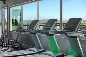 Treadmills and workout equipment line the wall of the fitness center at the Deck